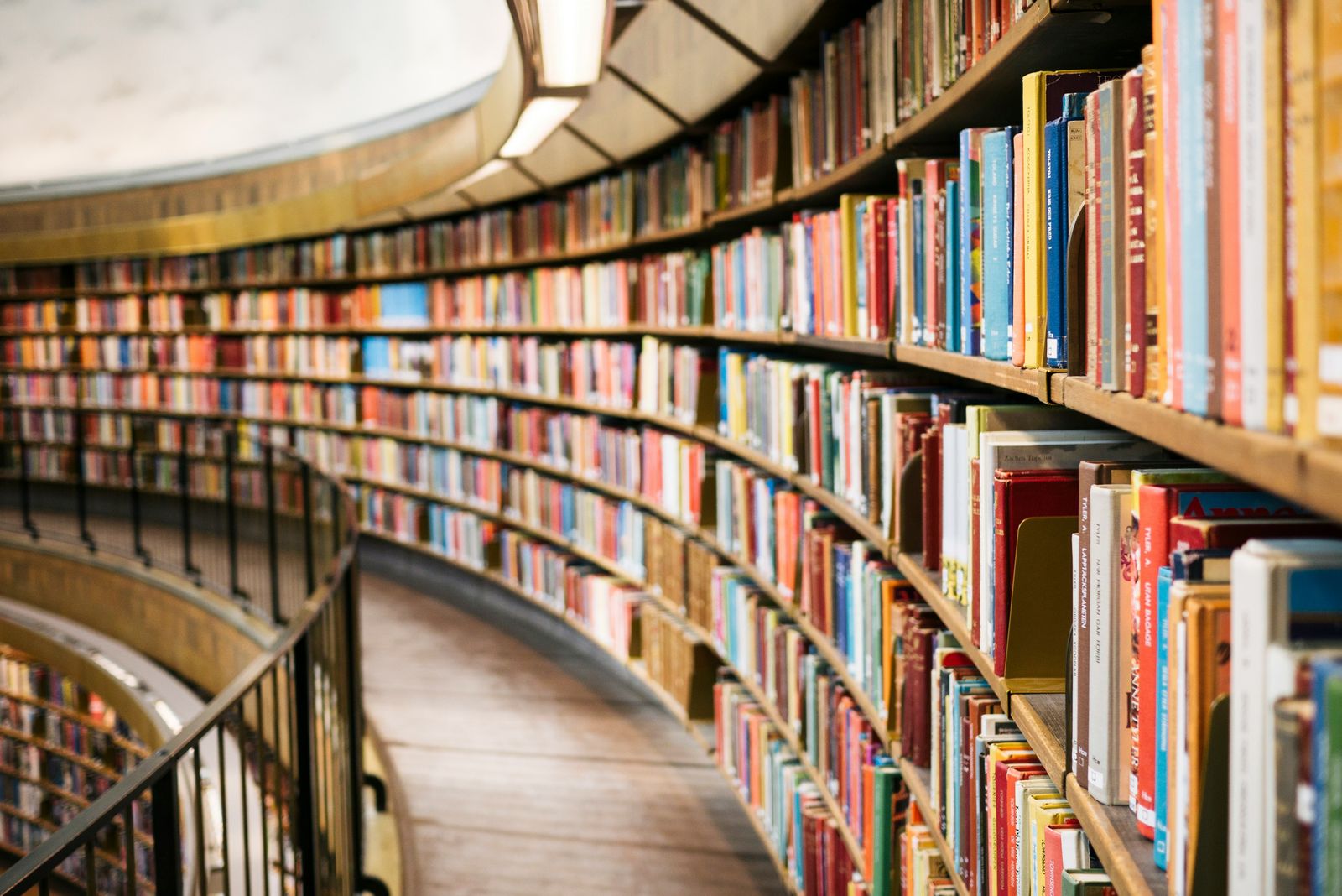 A curved wall of library shelves full of colourful books